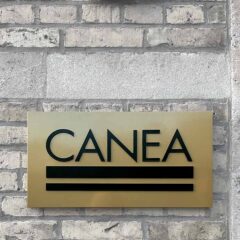 Fasadskylt "Canea" i infärgad aluminium i relief, med klack mot väggen och dold montering.